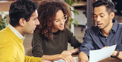 Two men and a woman looking at a document