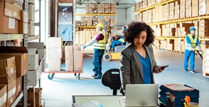 Businesswoman working on a computer in a warehouse
